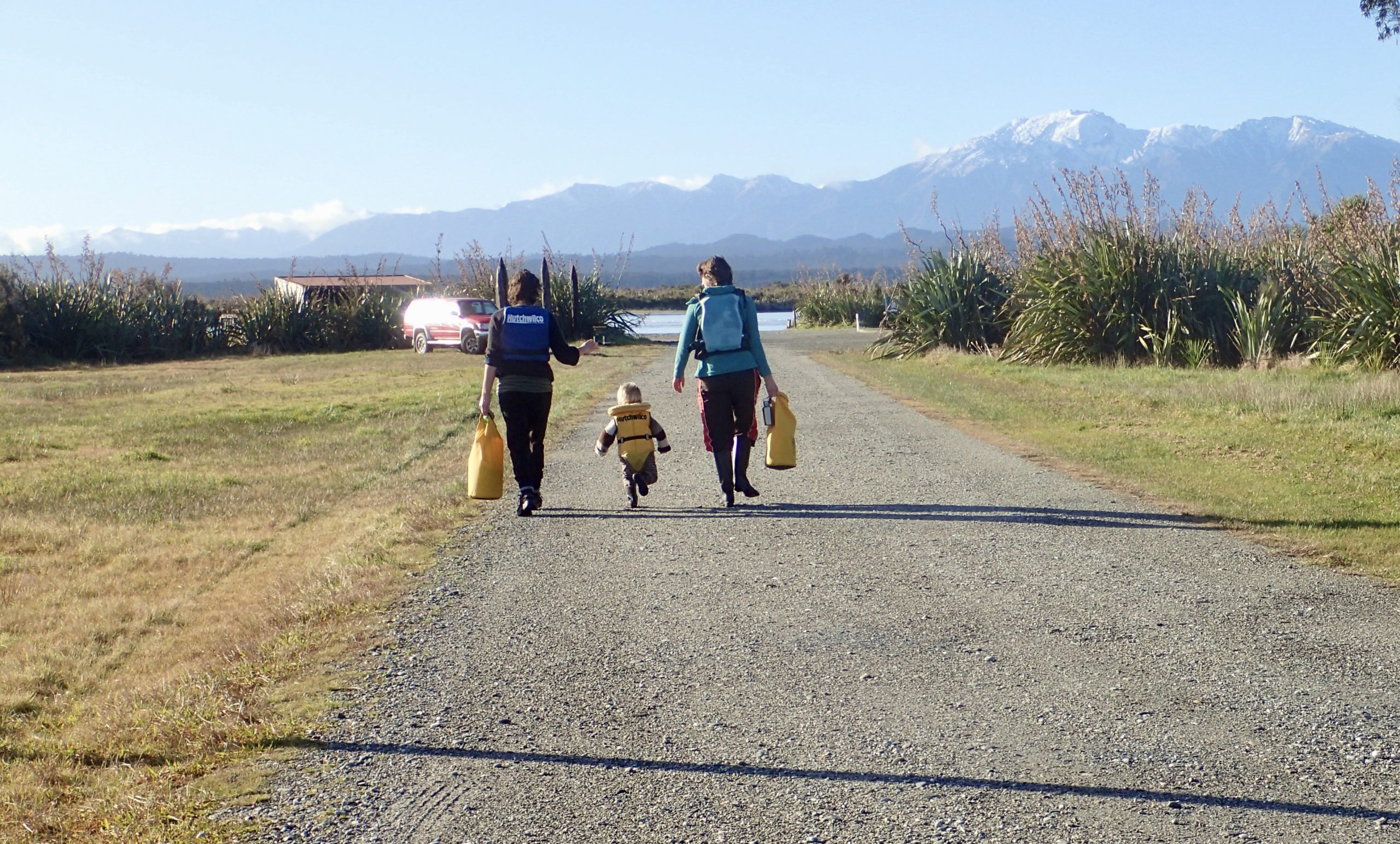 Family walk to kayaks at Ōkārito